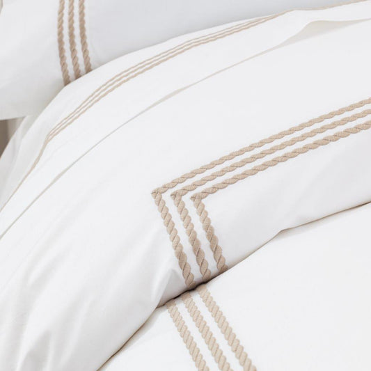 Windsor Sateen Fitted Sheet by Downright, styled on a bed